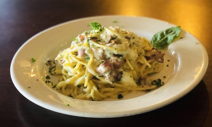 A plate of linguine carbonara with prosciutto and Parmesan